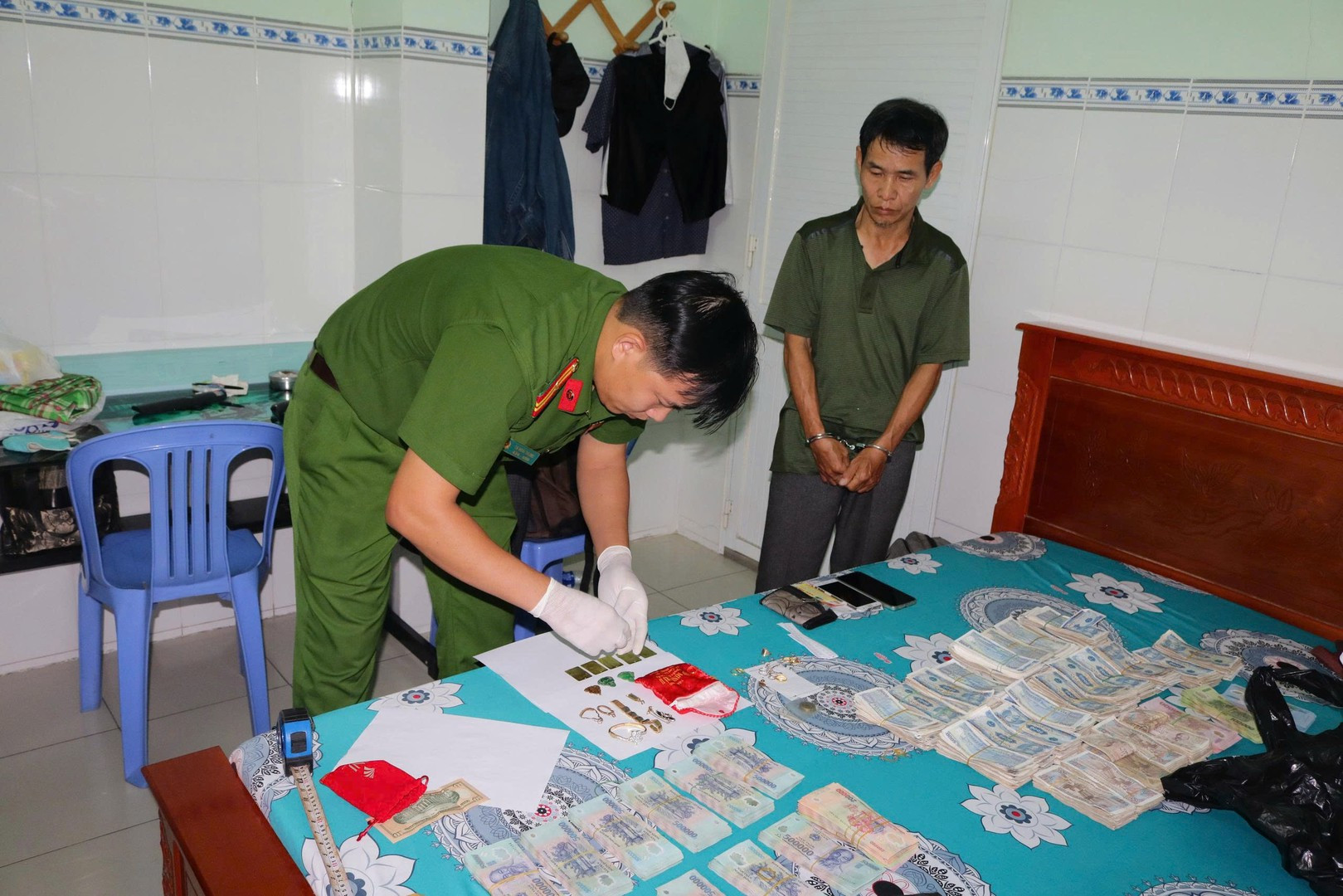 Lực lượng Công an đang kiểm tra tiền và trang sức Mai trộm. Ảnh Phước Thanh.jpg