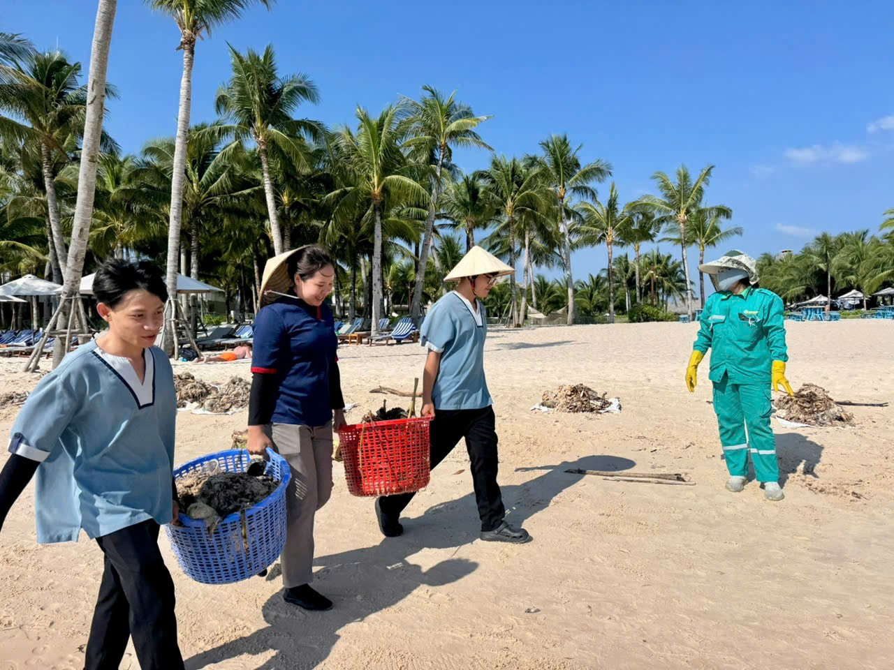 Nhân viên cảnh quan thu gom rác trôi dạt tại Bãi Kem để đảm bảo mỹ quan bãi biển.