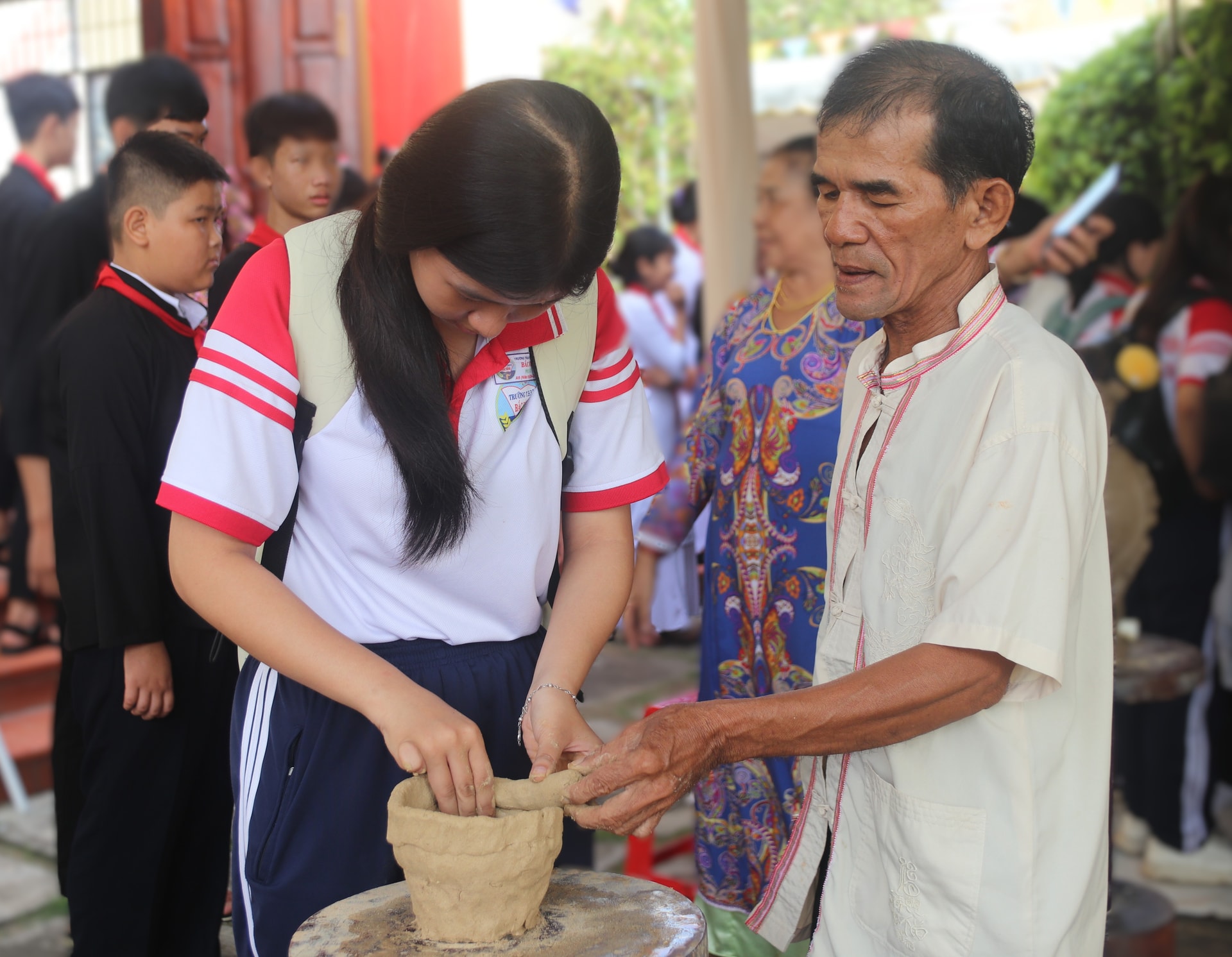 Elevii sunt îndrumați de artizani din satul de olari Binh Duc, comuna Bac Binh (provincia Lam Dong) cu privire la modul de realizare a ceramicii la roata olarului.