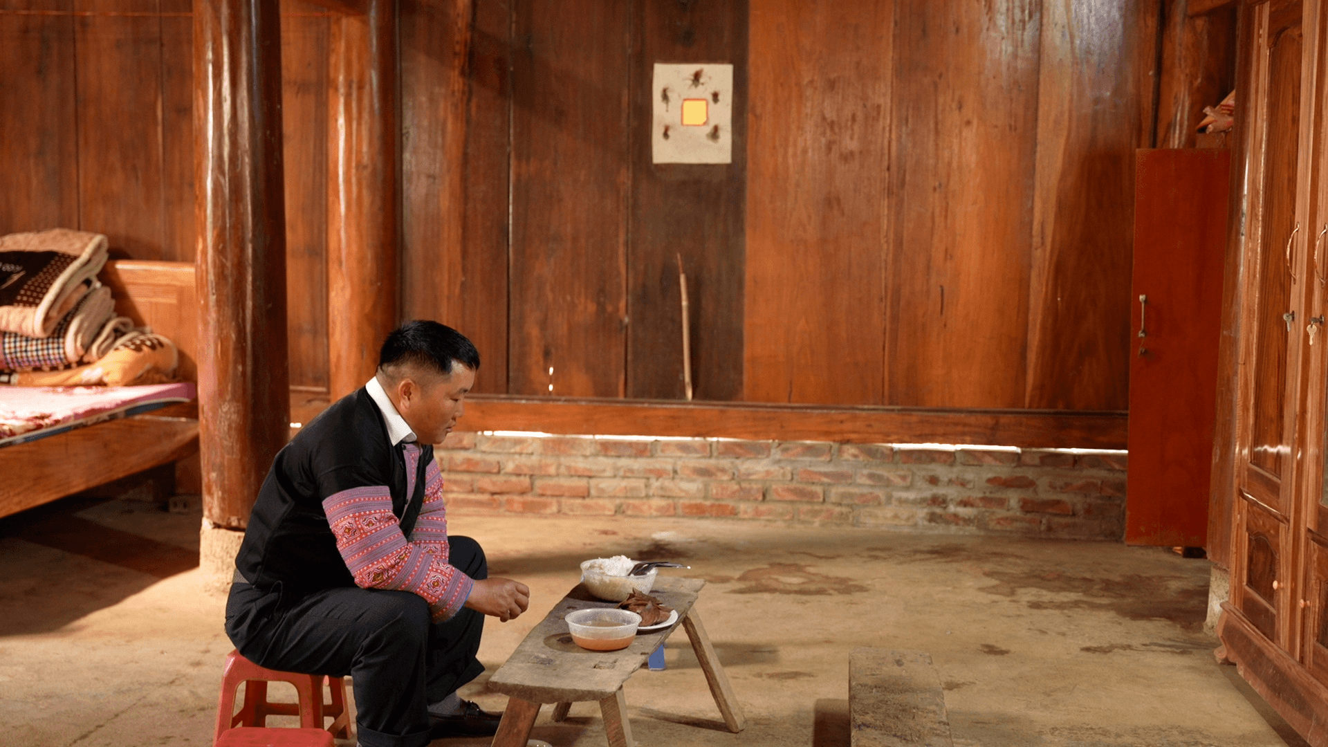 Nghi lễ cúng mời tổ tiên về ăn Tết của người Mông tại bản Pa Phách với rượu nếp và lá bùa dán bàn thờ.