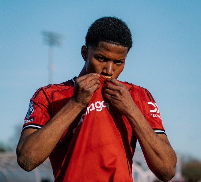 Chido Obi hôn lên huy hiệu MU sau khi ghi bàn thắng quan trọng vào lưới Man City.