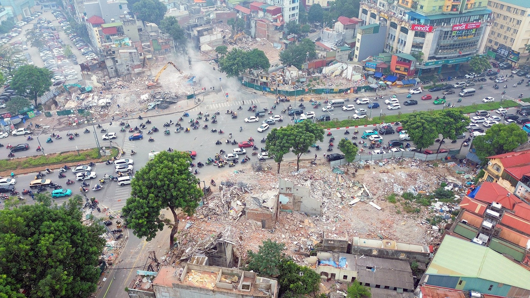 Công trường thi công đường Vành đai 1 đoạn Hoàng Cầu - Voi Phục với máy móc và công nhân đang làm việc.