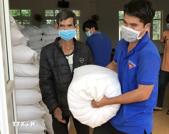 Người dân xã Quảng Khê, huyện Đắk G’Long, tỉnh Đắk Nông nhận gạo hỗ trợ của Chính phủ. (Ảnh: Hưng Thịnh/TTXVN) ttxvn-xuat-cap-gao.jpg