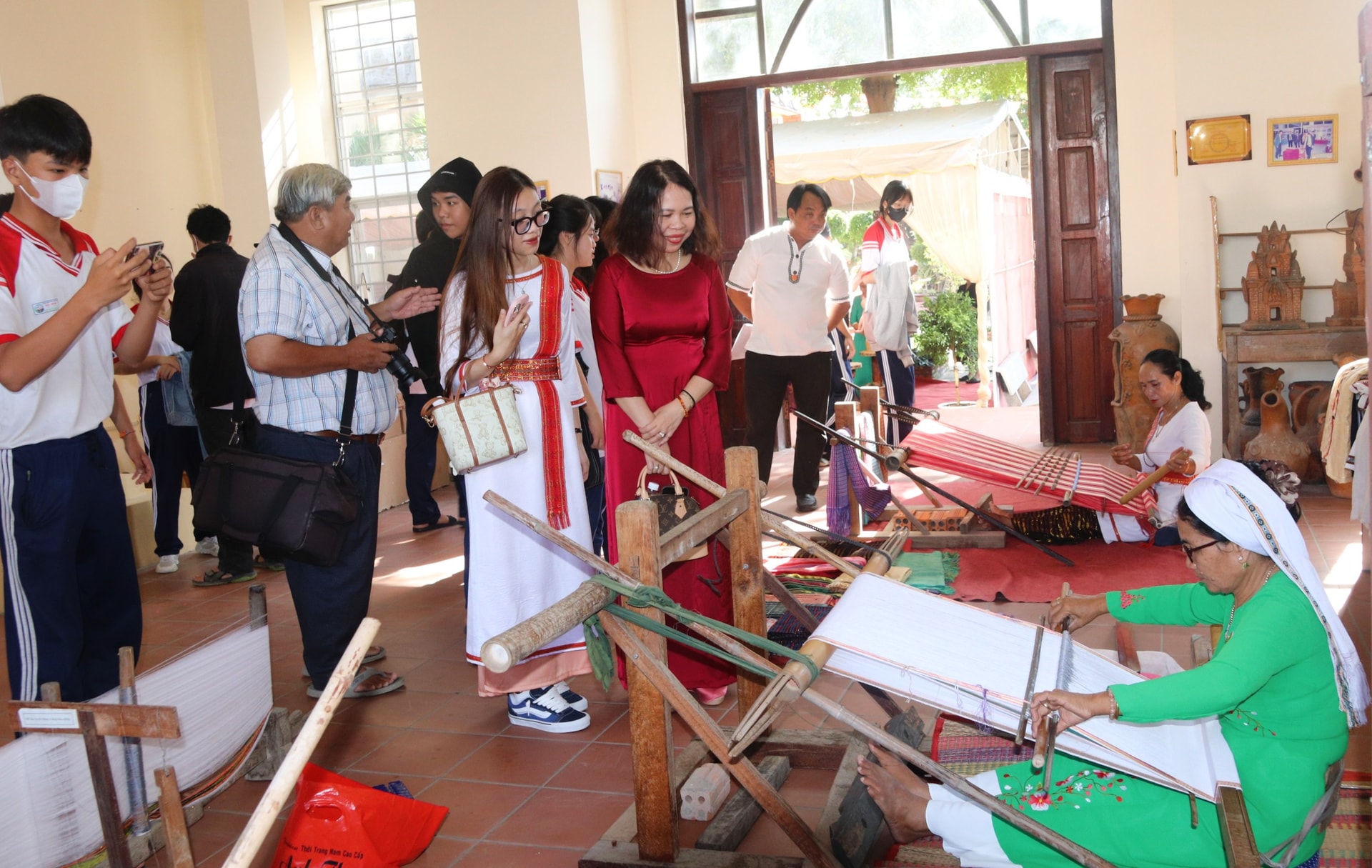 Học sinh v&agrave; c&aacute;c du kh&aacute;ch xem biểu diễn dệt truyền thống tại Trung t&acirc;m Trưng b&agrave;y văn h&oacute;a Chăm