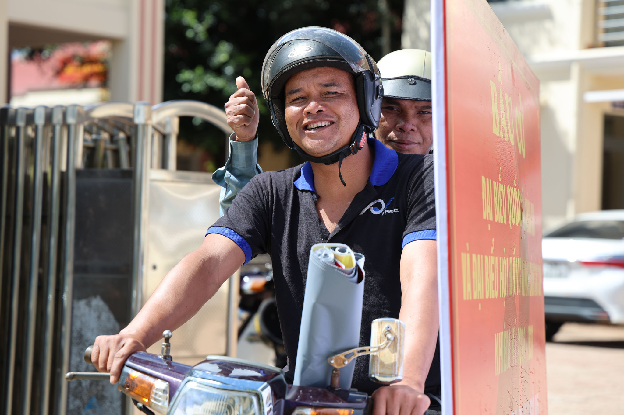 Cán bộ thôn vui mừng tiếp nhận pa-nô tuyên truyền bầu cử để triển khai treo tại khu dân cư