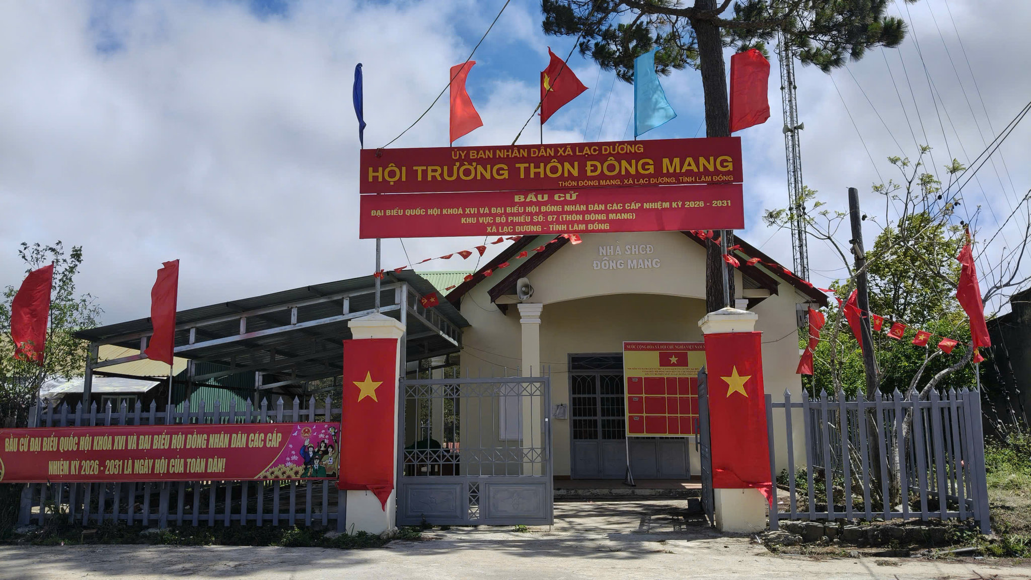 Cờ Tổ quốc và pa-nô tuyên truyền về bầu cử được trang trí tại nhà sinh hoạt cộng đồng thôn