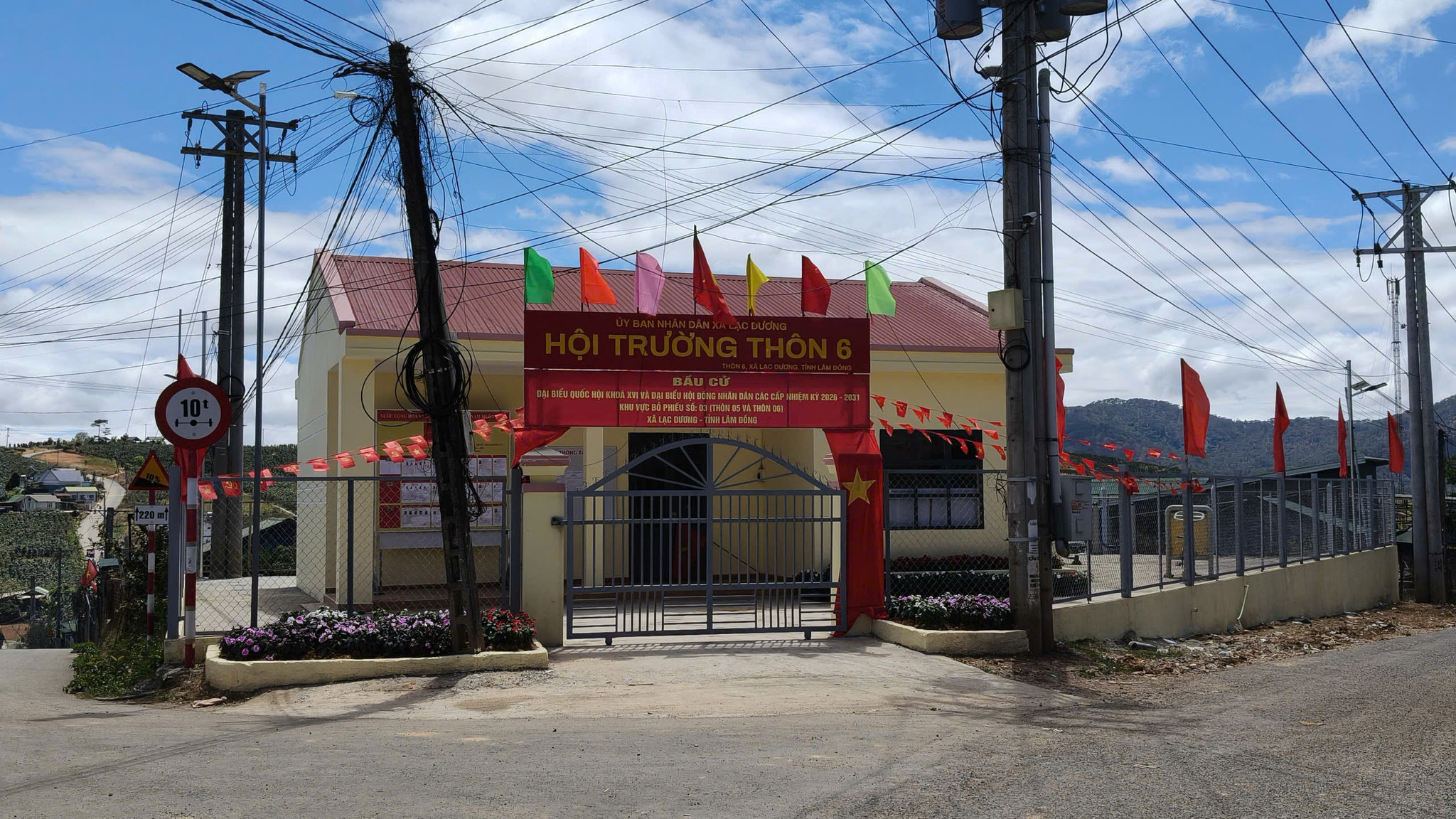 Khu vực nhà sinh hoạt cộng đồng thôn được trang trí pa-nô, khẩu hiệu tuyên truyền bầu cử