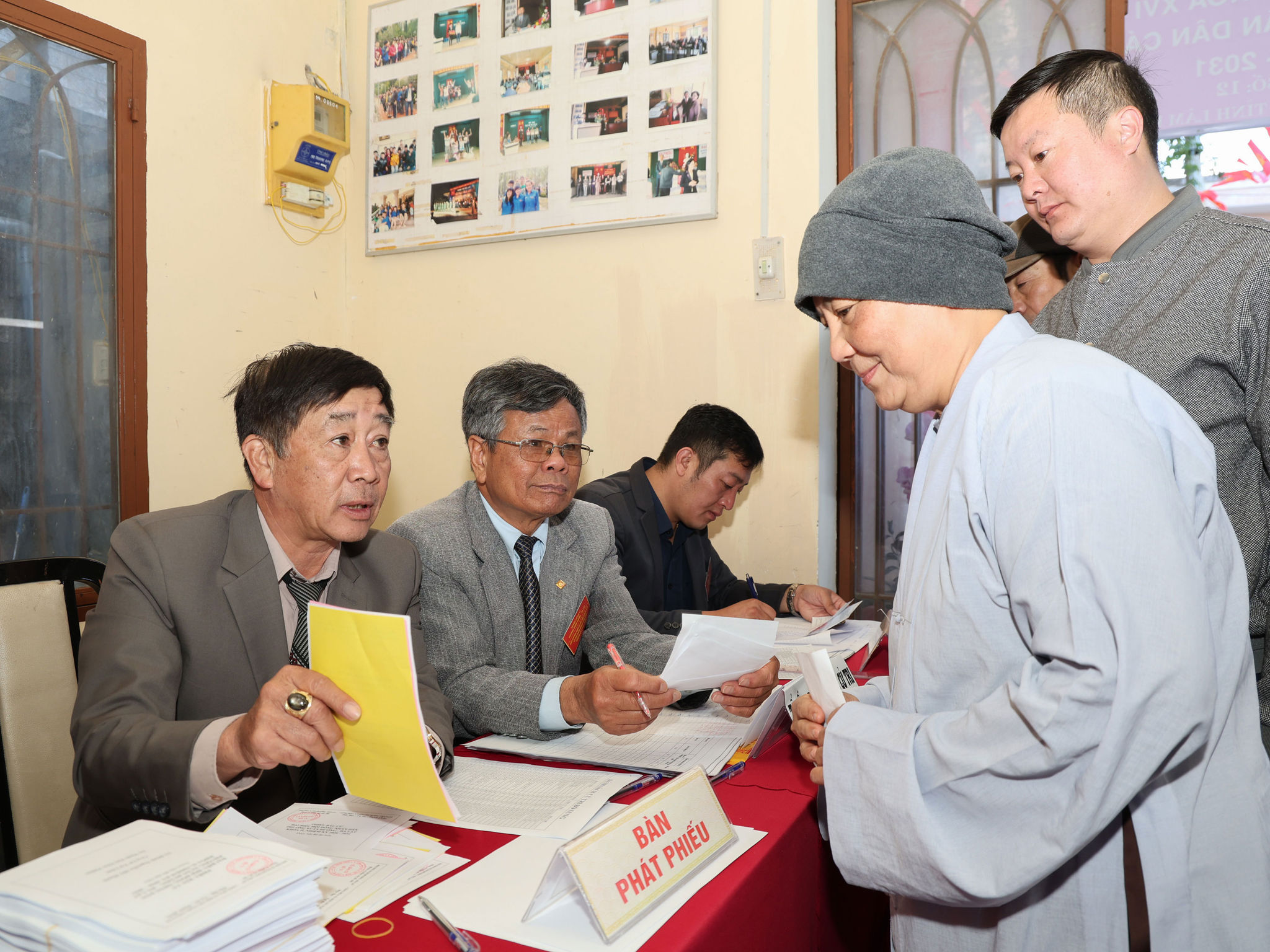 Ni cô lấy phiếu bầu cử và nghe hướng dẫn cách thức bầu cử tại khu vực bỏ phiếu số 12, đơn vị bầu cử số 6.