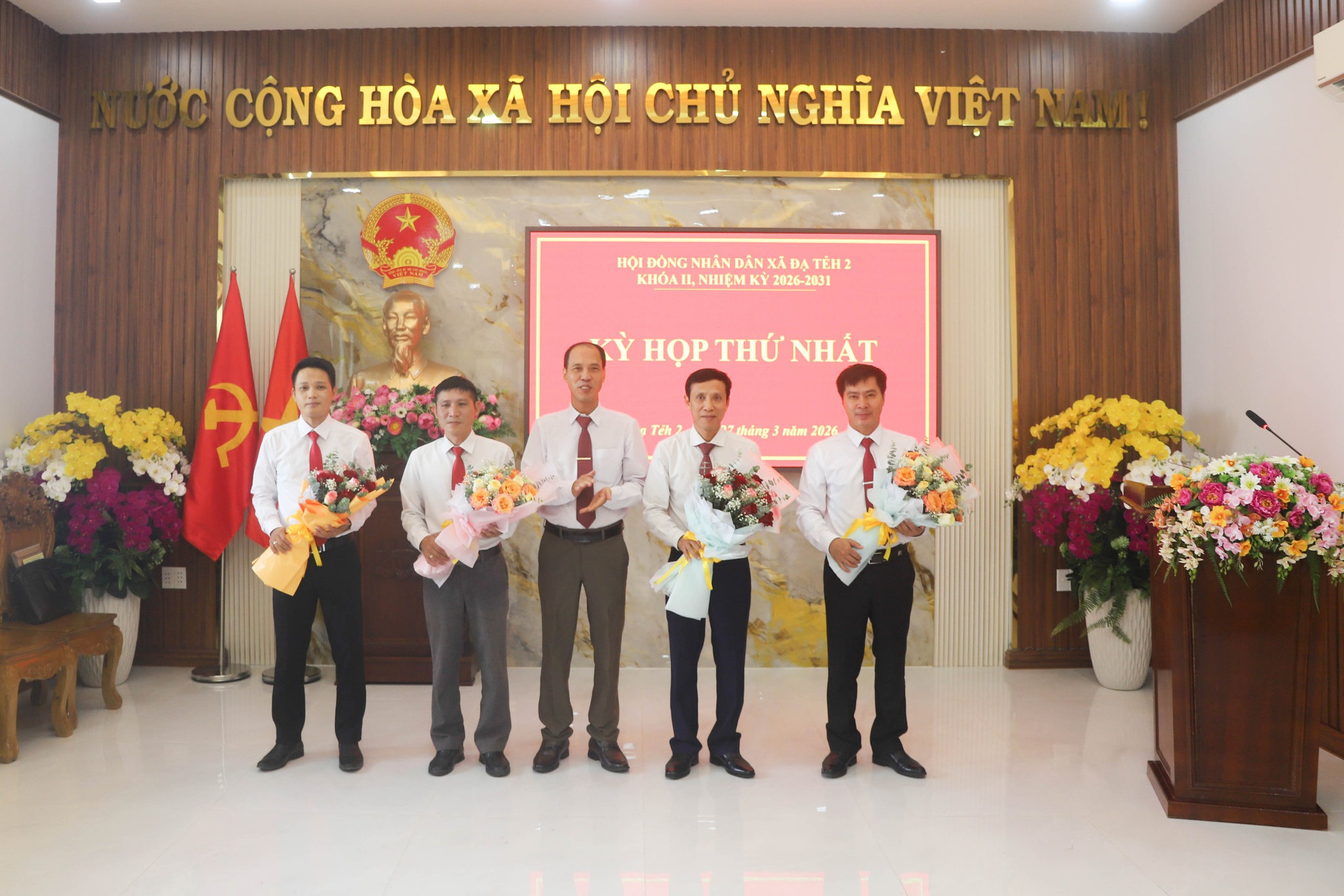 Đồng chí Phạm Xuân Tiên, Phó Bí thư Thường trực Đảng ủy xã Đạ Tẻh 2 tặng hoa chúc mừng các đại biểu được bầugiữ các chức vụ HĐND xã nhiệm kỳ mới 