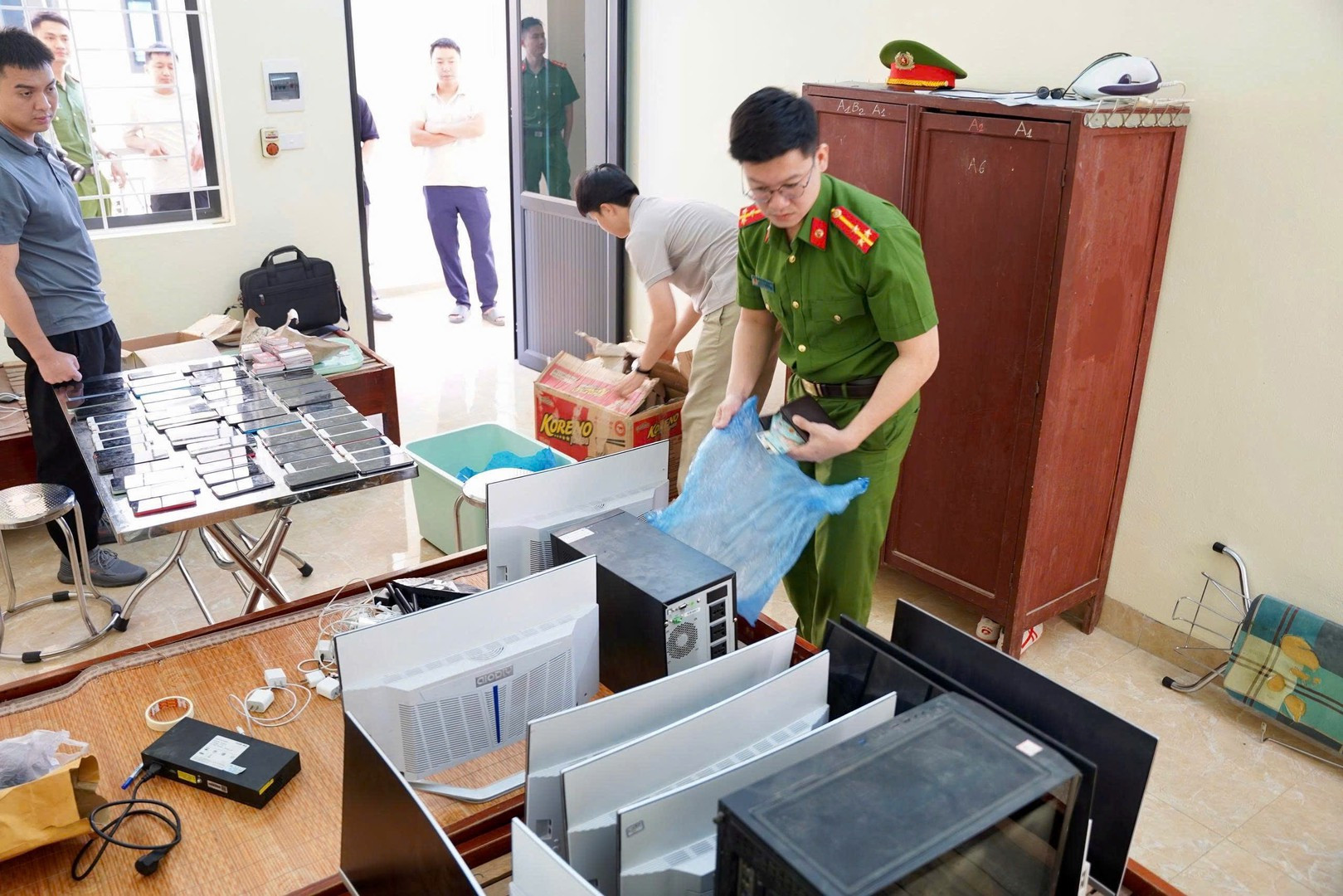 Lực lượng chức năng kiểm tra tang vật thu giữ được từ các đối tượng lừa đảo.