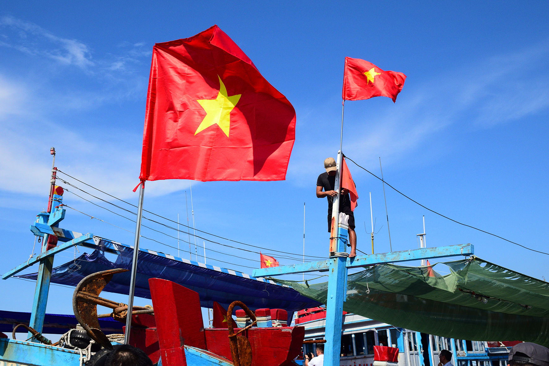 Ngư dân thay cờ mới trên tàu cá