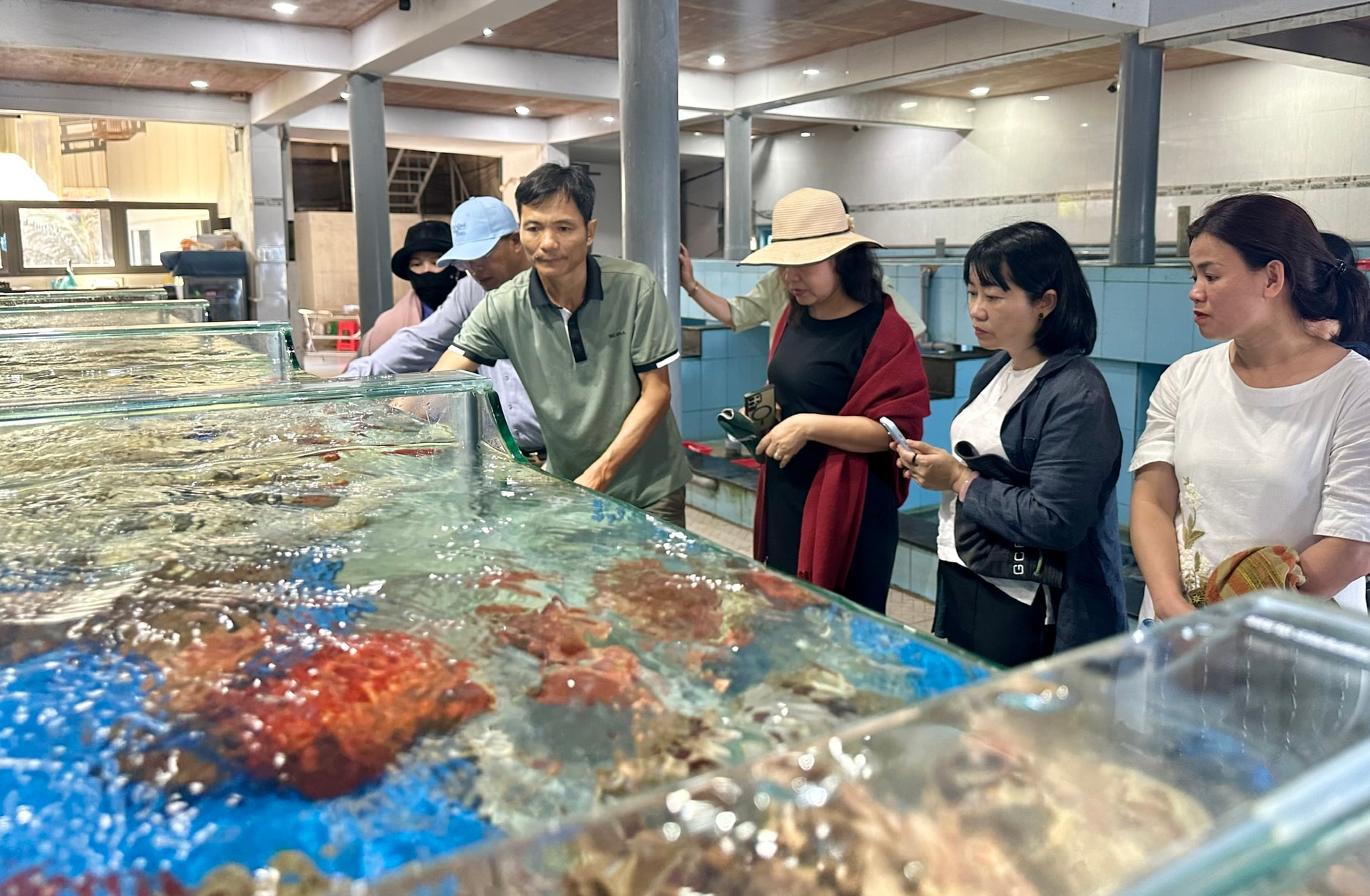 관광객들이 방문하여 신선한 해산물을 고릅니다.