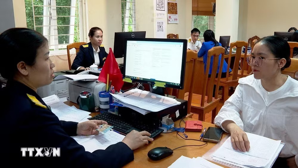 Cán bộ Thuế Link vào Phú Thọ hướng dẫn hộ kinh doanh kê khai thuế. (Ảnh: Nguyễn Thảo/TTXVN) ttxvn-giup-ho-kinh-doanh-ke-khai-thue.jpg