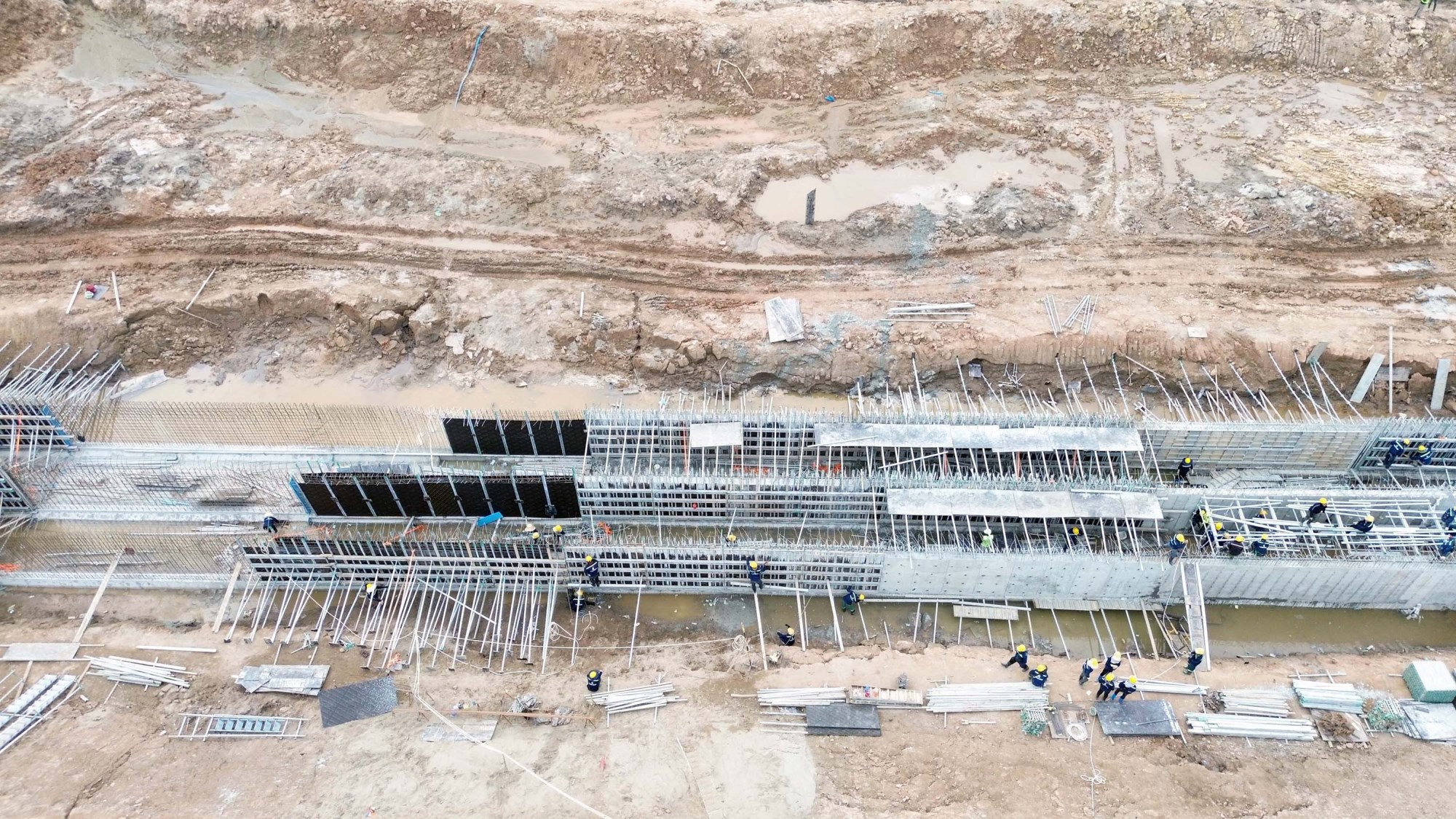 Công nhân và máy móc đang đẩy nhanh tiến độ thảm nhựa và lu lèn nền đường