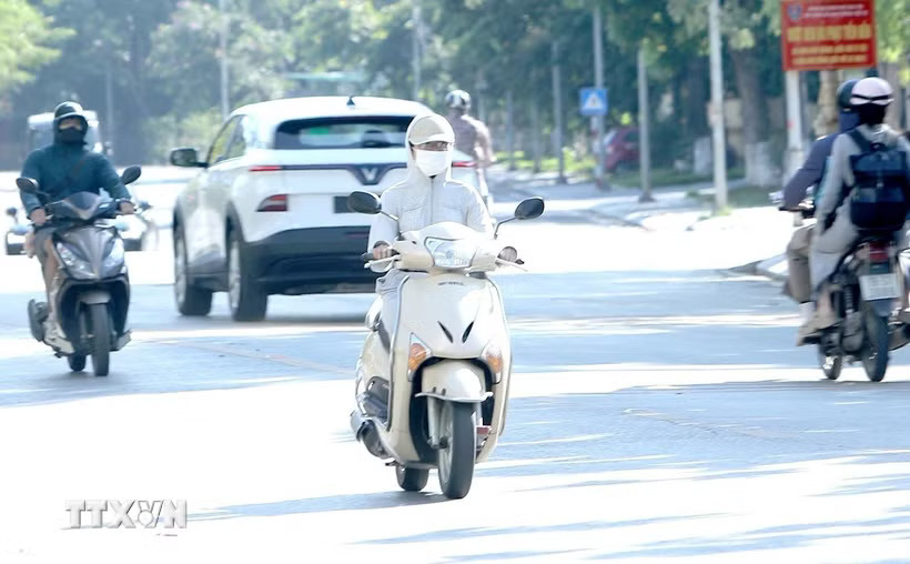 Trang phục kín mít là một lựa chọn tối ưu để đối phó với thời tiết nắng nóng. (Ảnh: Hoàng Hùng/TTXVN)