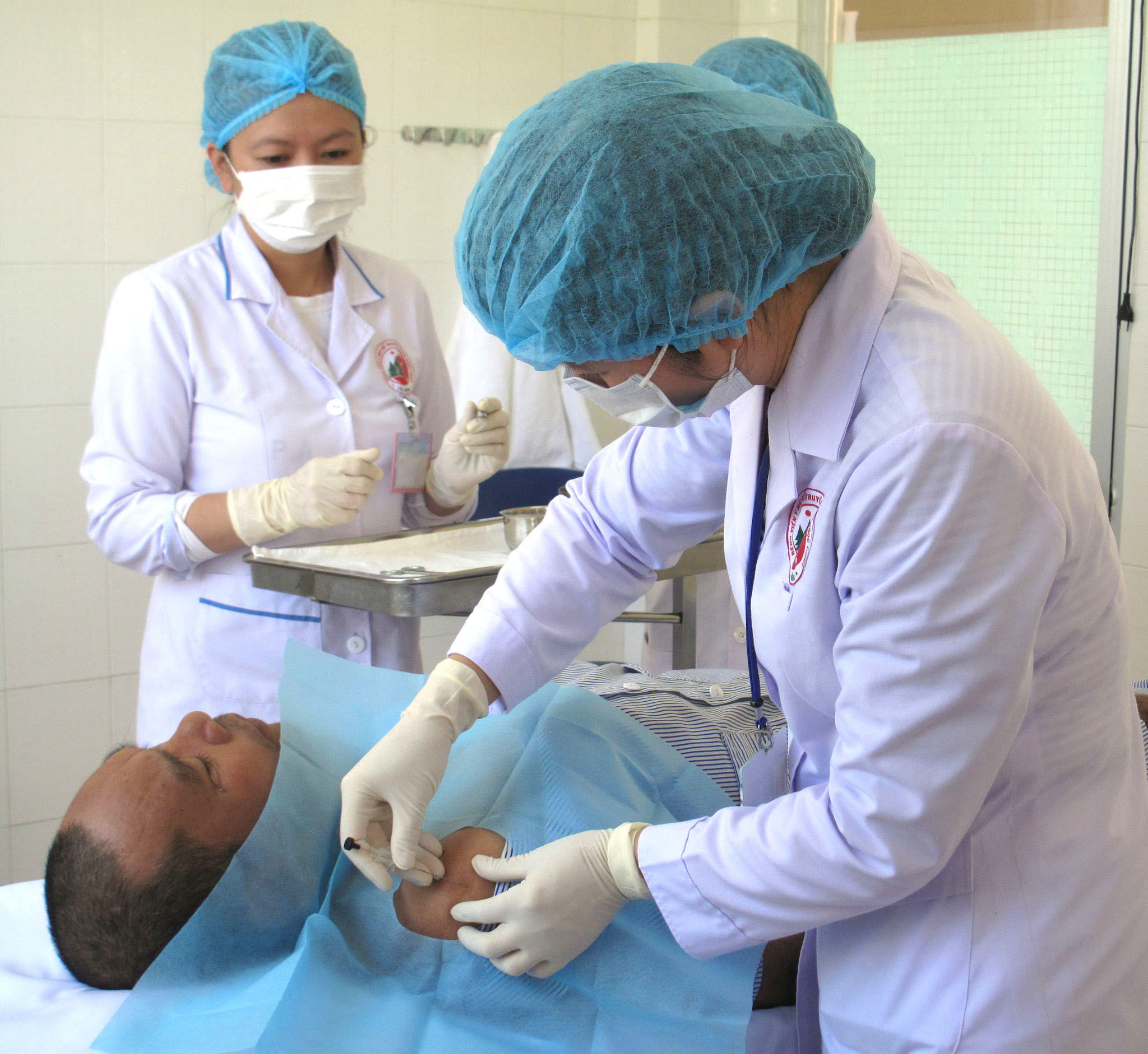 Figura 2 - Il Dr. Doan Ngoc Khanh sta eseguendo la procedura di impianto di filo sul paziente (1)