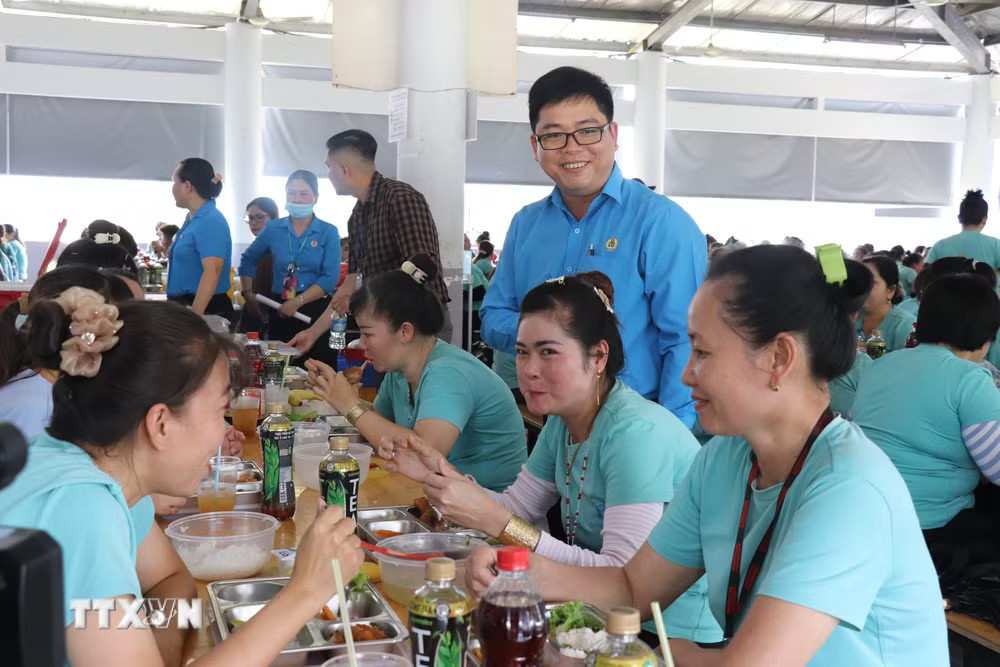 Công nhân dùng “Bữa cơm Công đoàn”. (Ảnh: Thanh Bình/TTXVN) ttxvn-bua-an-cong-doan.jpg