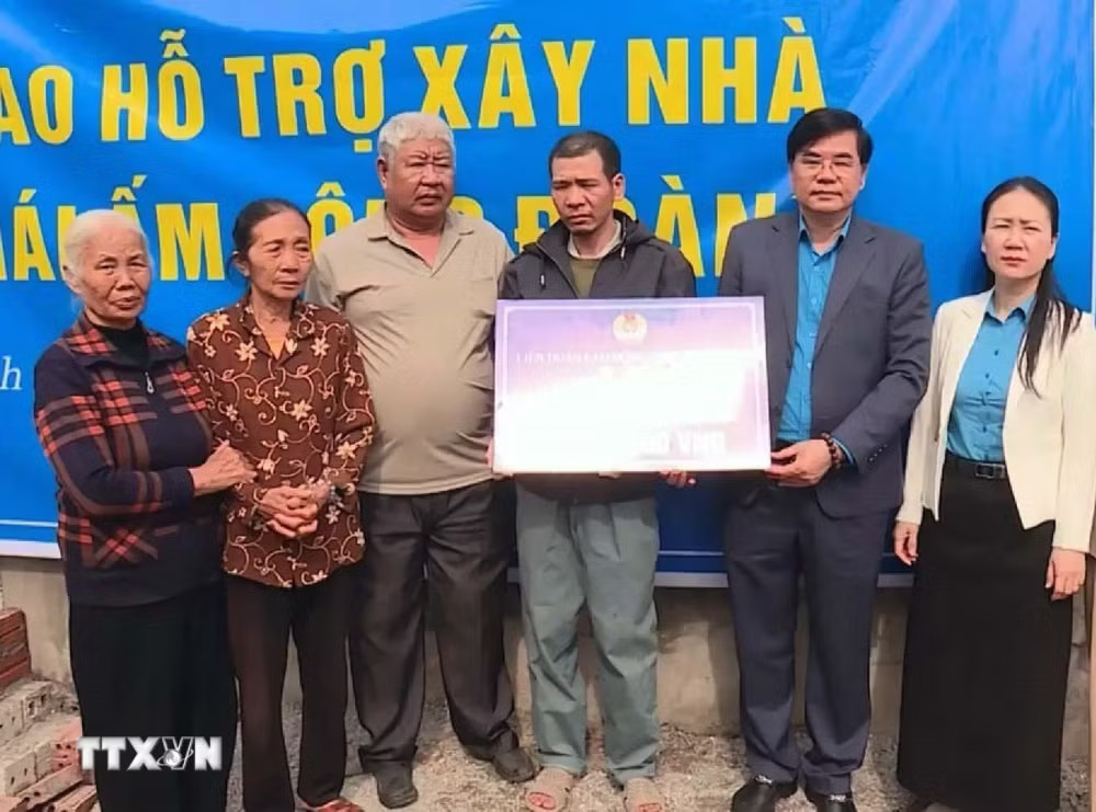 Ông Nguyễn Hải Long, Chủ tịch Liên đoàn Lao động Link vào Ninh Bình trao hỗ trợ 50 triệu đồng cho đoàn viên công đoàn xây dựng nhà Mái ấm công đoàn. (Ảnh: Đại Nghĩa/TTXVN) ttxvn-mai-am-cong-doan.jpg