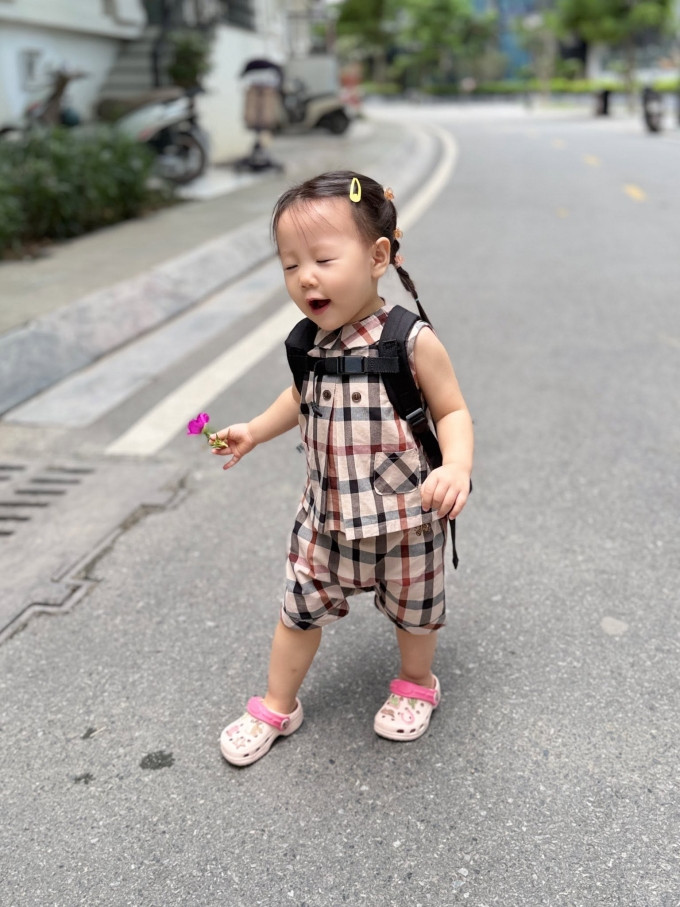 Bức ảnh Jenny thể hiện sự thích thú khi được mẹ tặng một bông hoa trên đường đi học thu hút hàng nghìn lượt thích.