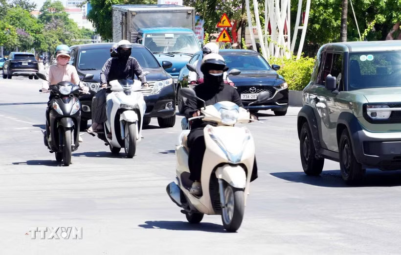 Người dân Quảng Trị trang bị áo chống nắng khi lưu thông ngoài trời trong điều kiện nắng nóng gay gắt. (Ảnh: Tá Chuyên/TTXVN)