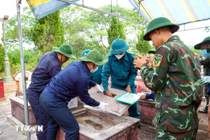 Các lực lượng tham gia khai quật, lấy mẫu ADN phần mộ liệt sỹ. (Ảnh: Hữu Quyết/TTXVN)