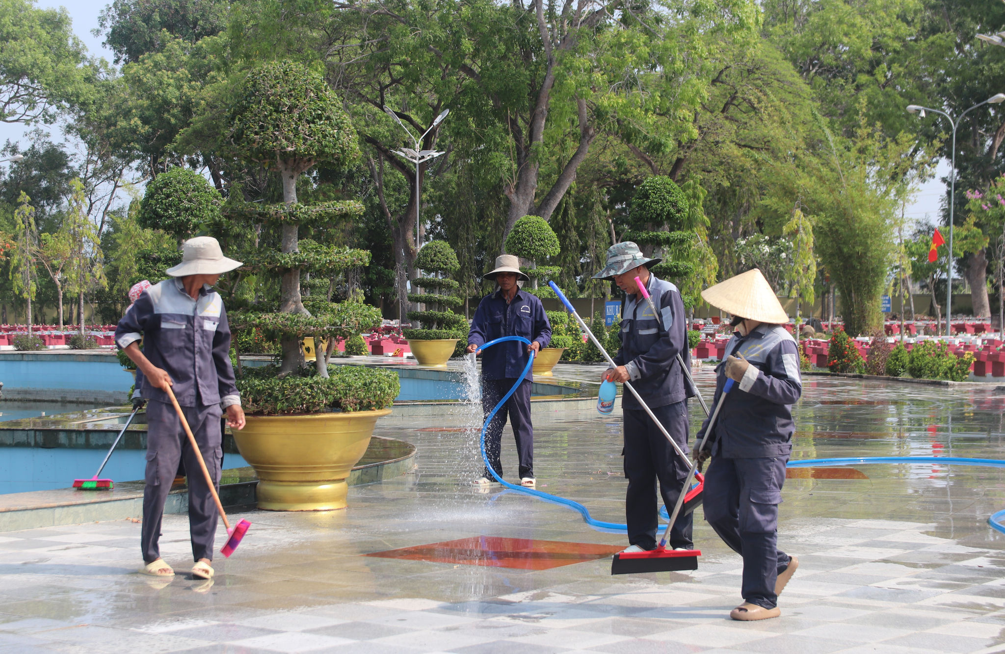 Những người quản trang đang quét dọn để khuôn viên nghĩa trang luôn sạch sẽ