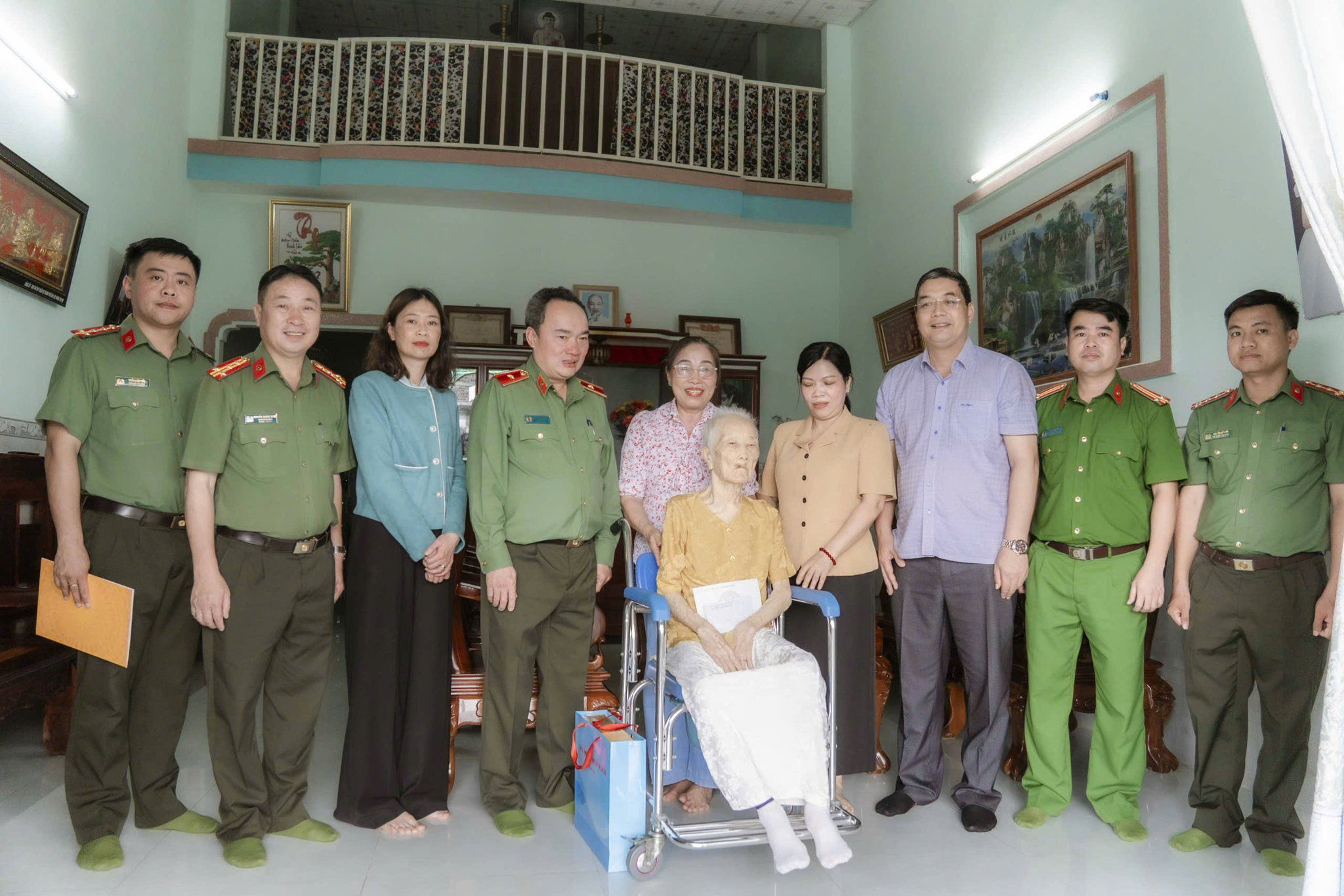 Đồng chí giám đốc công an tỉnh chụp hình lưu niệm cùng gia đình mẹ Việt Nam anh hùng Bùi Thị Xê - Ảnh Lê Tiến