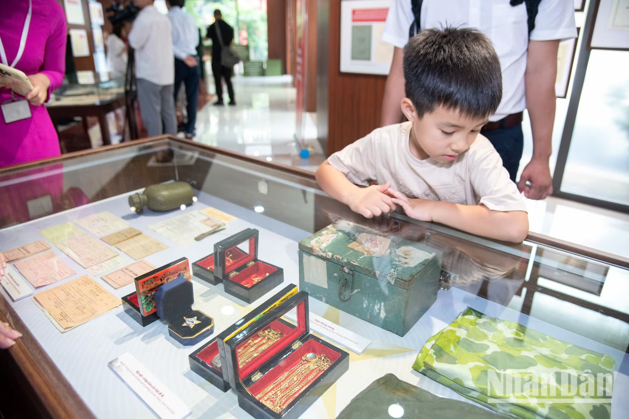 Cậu bé 6 tuổi chăm chú nhìn những kỷ vật nhỏ bé của cha ông. Những bài học về lòng yêu nước bắt đầu từ những trải nghiệm thực tế thế này. trien-lam-di-b-minh-duy-37.jpg