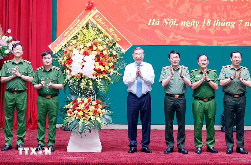 Tổng Bí thư, Chủ tịch nước Tô Lâm tặng hoa chúc mừng lực lượng Cảnh sát nhân dân. (Ảnh: Thống Nhất/TTXVN)