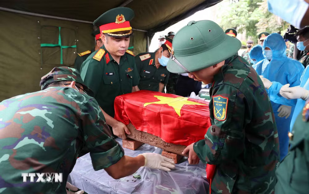 Trang trọng thực hiện quy trình khai quật, đưa hài cốt liệt sỹ chưa xác định danh tính về khu vực lấy mẫu sinh phẩm liệt sỹ tại Nghĩa trang Liệt sỹ Ngọc Hồi (xã Thanh Trì). (Ảnh: Văn Điệp/TTXVN) ttxvn-3007-hai-cot-liet-sy-ha-noi.jpg