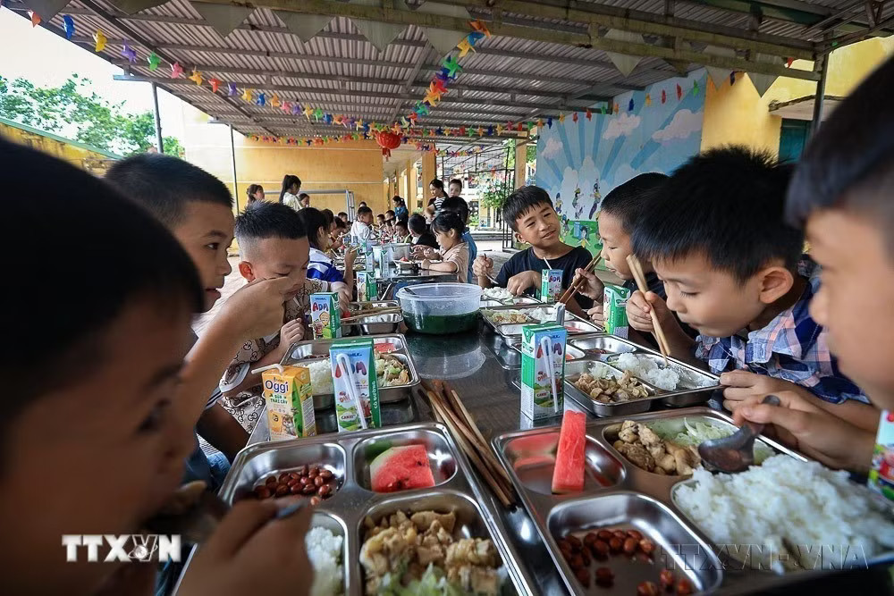 Trong không khí vui vẻ và ấm áp, các học sinh xóm Rằng (Hòa Bình) ăn suất cơm trưa bán trú ngon miệng. (Ảnh: Trọng Đạt/TTXVN) ttxvn-thang-hanh-dong-vi-tre-em-va-ngay-quoc-te-thieu-nhi-16-tre-em-hanh-phuc-an-toan-vung-buoc-trong-ky-nguyen-so-8789197-5.jpg