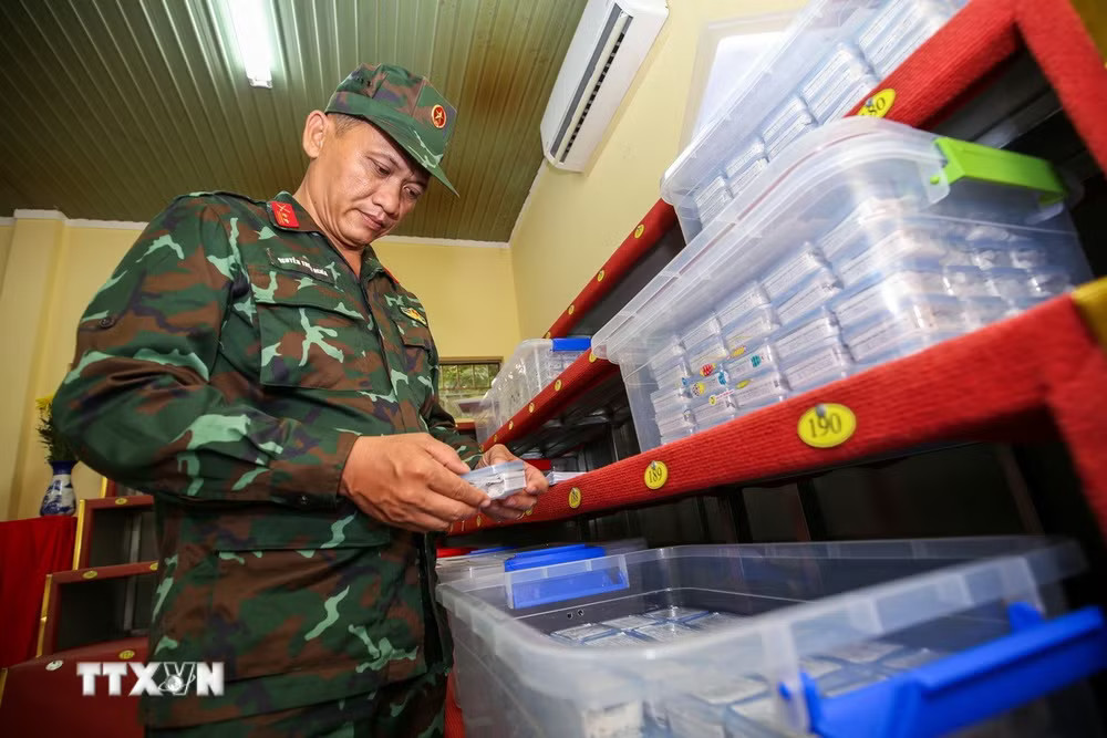 Trung tá Nguyễn Thiện Nghĩa kiểm tra, đối chiếu và tiếp nhận các mẫu hài cốt trước khi bàn giao cho đơn vị chuyên môn phục vụ giám định ADN. (Ảnh: Giang Phương/TTXVN) ttxvn-chien-dich-500-ngay-dem-tay-ninh-3.jpg