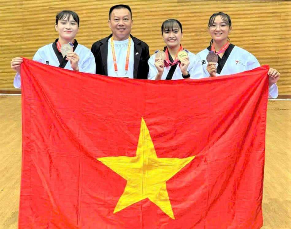 Martial arts instructor Nguyen Quoc Hung with his students Le Kim, Kim Ha and Phuong Nhung after winning gold medals at the 2025 Southeast Asian Taekwondo Championships