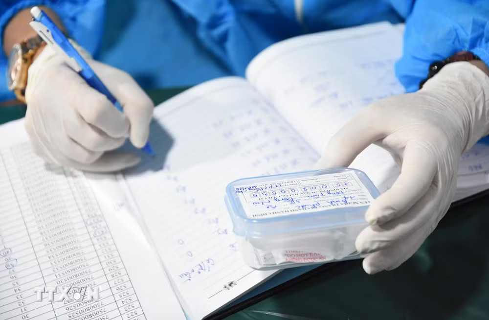Toàn bộ quy trình lấy mẫu ADN hài cốt liệt sỹ được thực hiện nghiêm ngặt theo quy định, bảo đảm chính xác, không để xảy ra sai sót ở bất kỳ khâu nào. (Ảnh: Đậu Tất Thành/TTXVN) ttxvn-adn.jpg