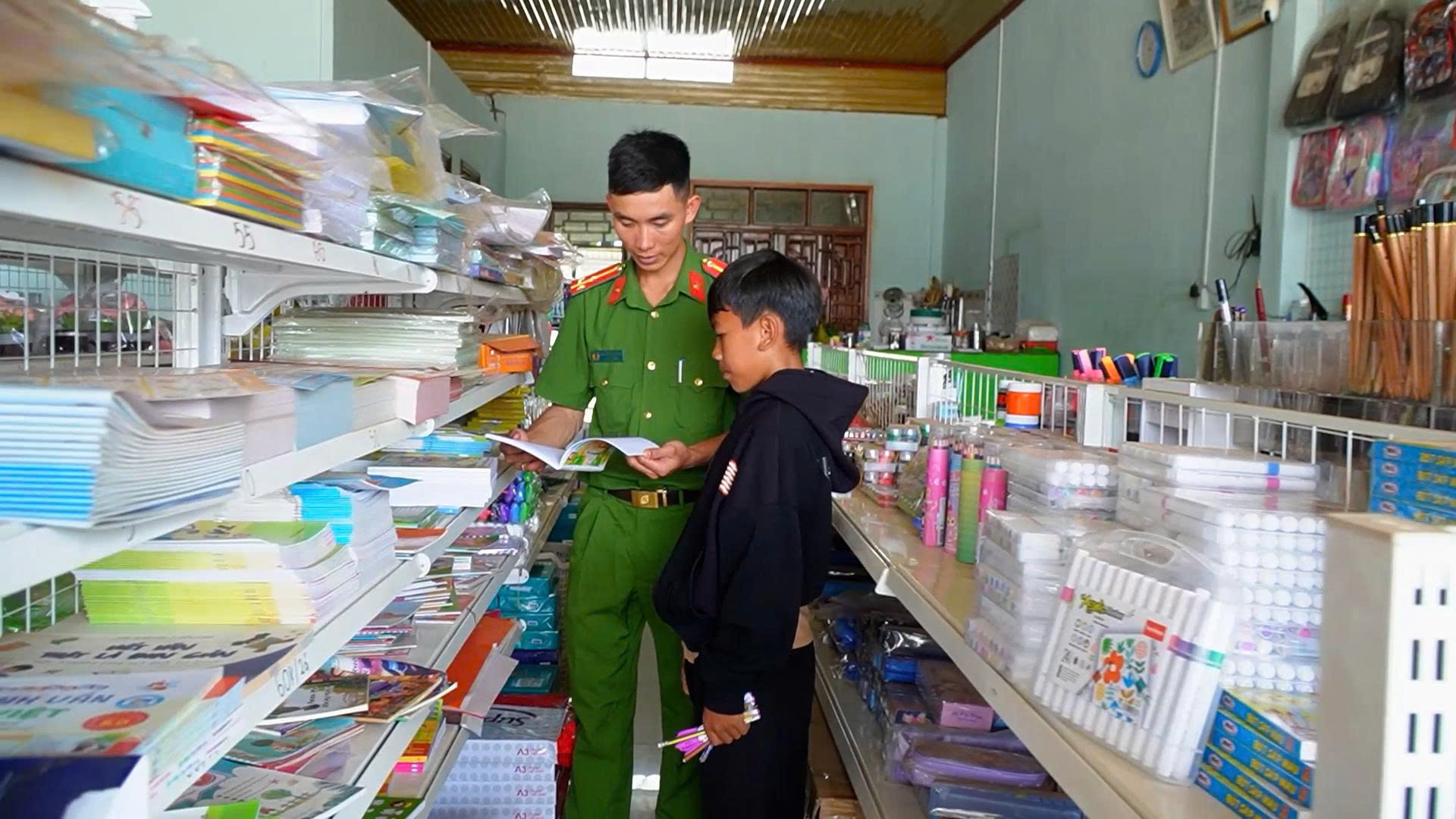 Cán Bộ Công an xã Quảng Trực đưa Điểu Giáp mua sách vở, đồ dùng học tập chuẩn bị cho năm học mới.