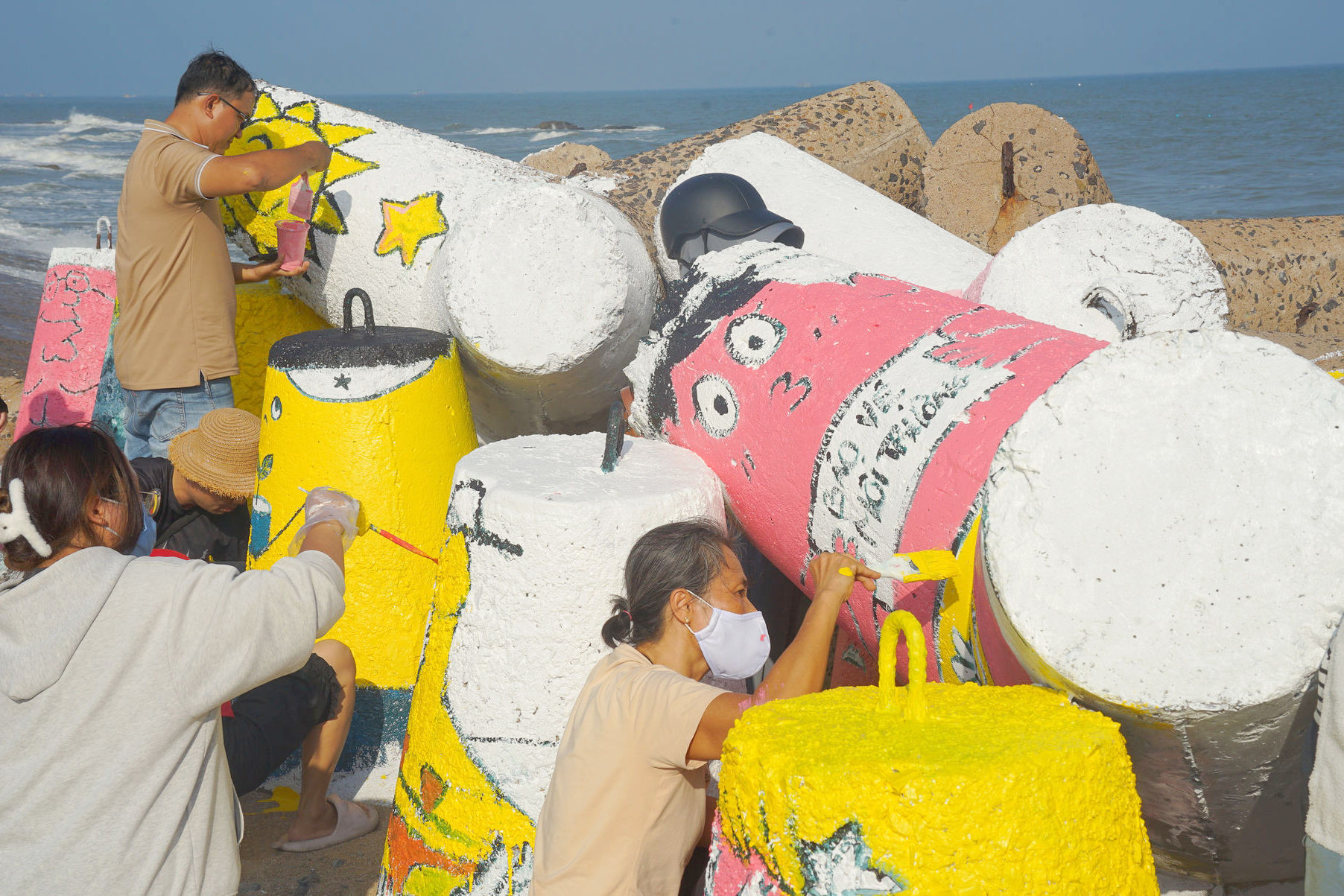 Volunteers work diligently on each tetrapod