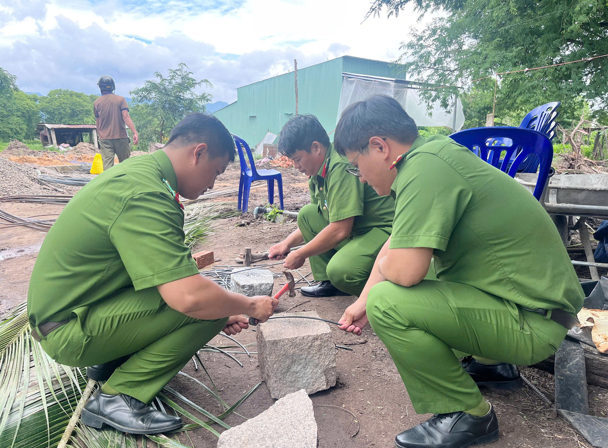 Cán bộ, chiến sĩ Công an xã Hàm Thuận Bắc hỗ trợ cắt thép làm nhà cho gia đình anh Dũng.