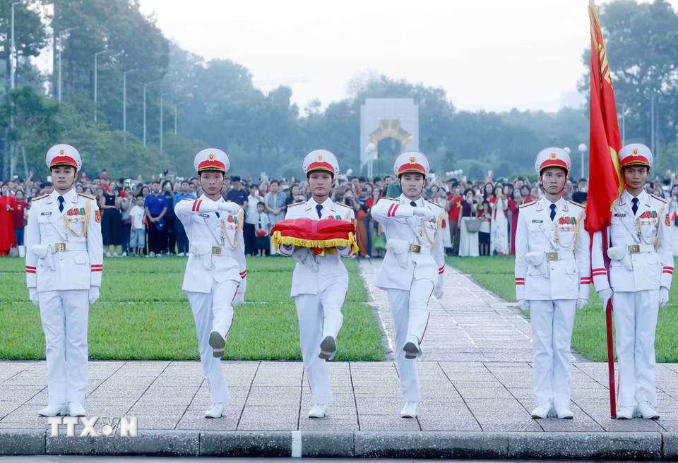 Ba chiến sỹ mang Quốc kỳ tiến về phía cột cờ chuẩn bị thực hiện nghi Lễ Thượng cờ. (Ảnh: Phạm Kiên/TTXVN)