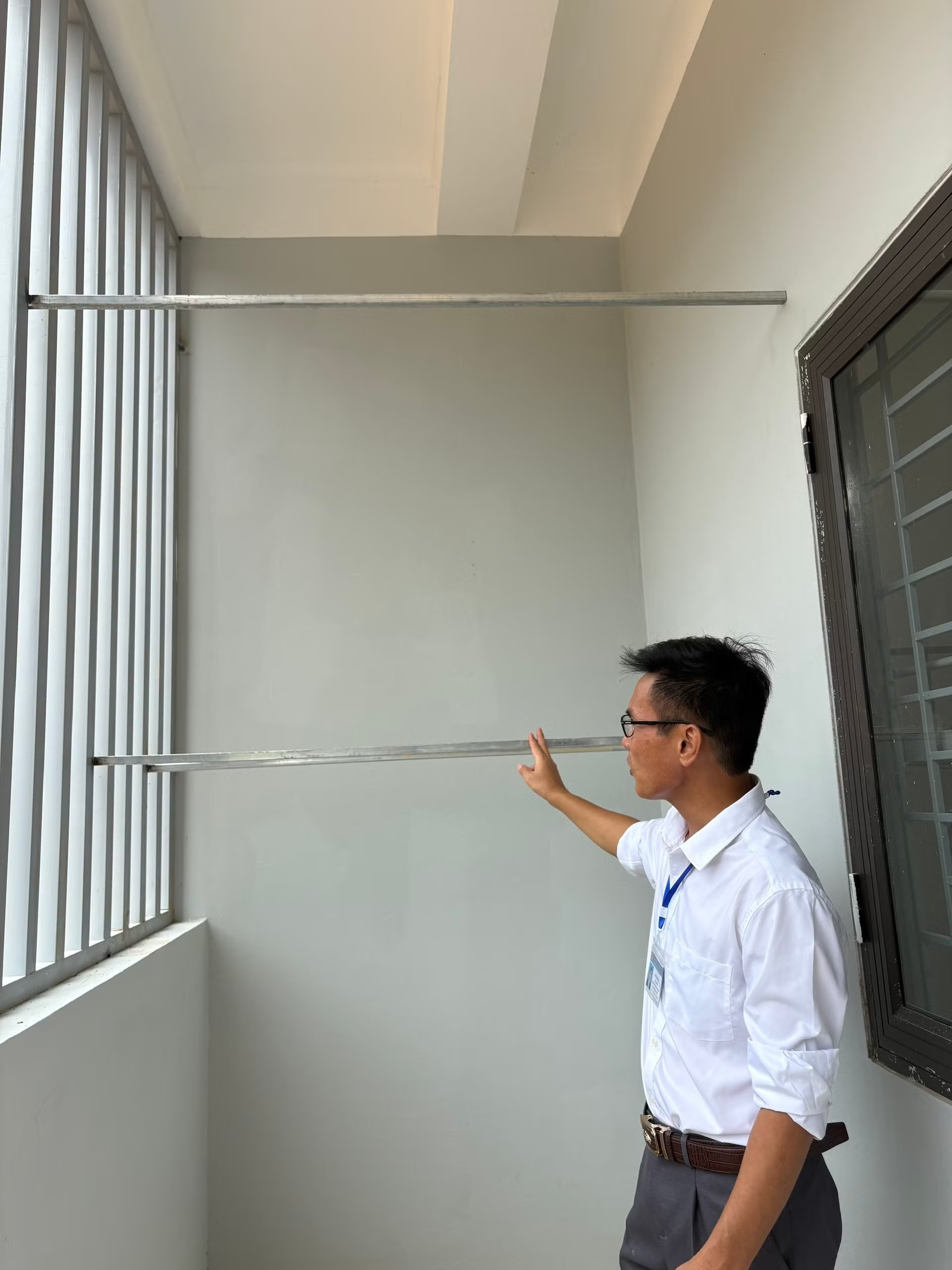 Thầy Nguyễn Trọng Sơn kiểm tra việc gắn thanh phơi quần áo ở khu nhà ở nội trú của học sinh. (Ảnh: Phạm Mai/Vietnam+) sam-mun.jpg