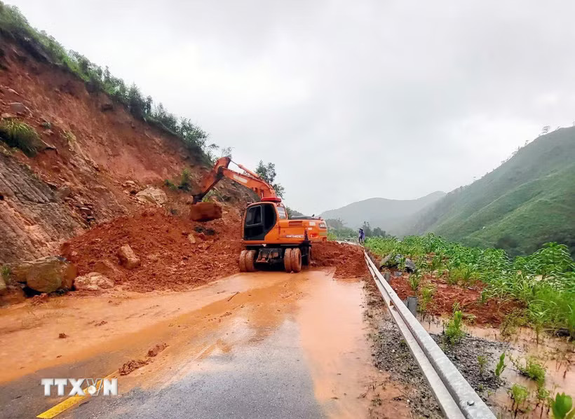 Lực lượng chức năng thu dọn đất đá sạt lở. (Ảnh: Phạm Lợi/TTXVN)