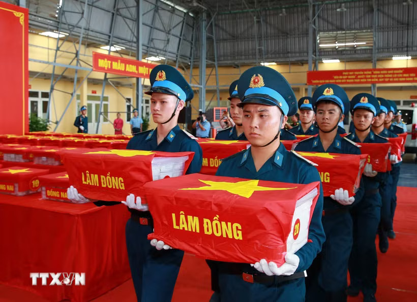 Di chuyển mẫu hài cốt các liệt sỹ từ máy bay đến vị trí làm lễ dâng hương. (Ảnh: Trọng Đức/TTXVN)