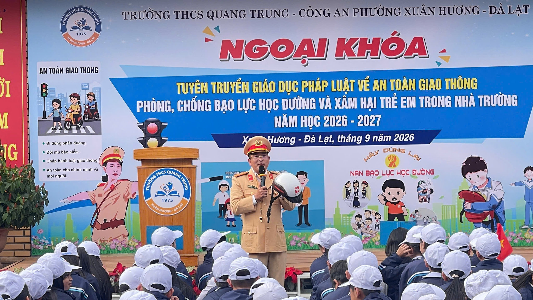 Cán bộ CSGT hướng dẫn học sinh đội mủ bảo hiểm đúng cách. Ảnh Phương Thanh.
