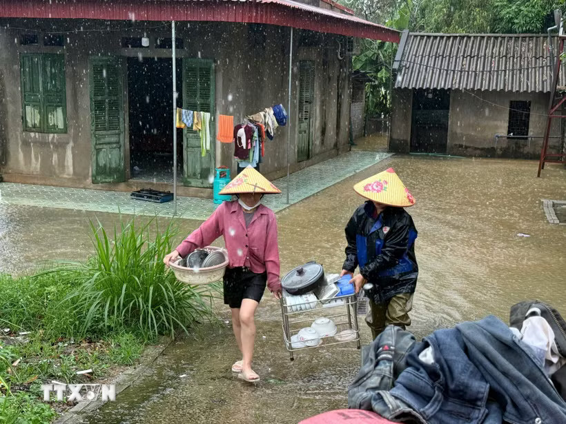 Người dân sơ tán vật dụng lên cao để tránh lũ. (Ảnh: Hoa Mai/TTXVN)