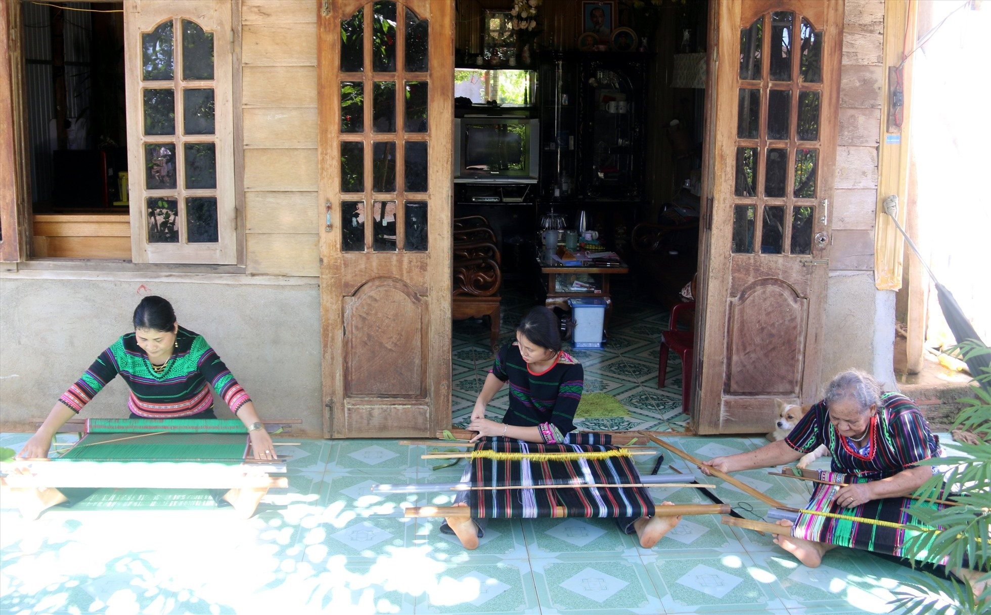 3 thế hệ ngồi bên khung dệt.