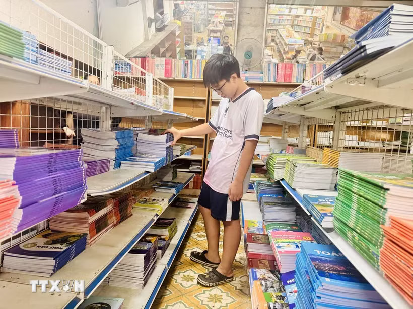 Học sinh tìm mua sách giáo khoa. (Ảnh: Hoàng Ngà/TTXVN)
