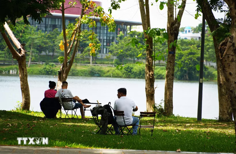 Người dân đến công viên bờ Bắc sông Hương, thành phố Huế để hóng mát, tránh nắng. (Ảnh: Nguyên Lý/TTXVN)