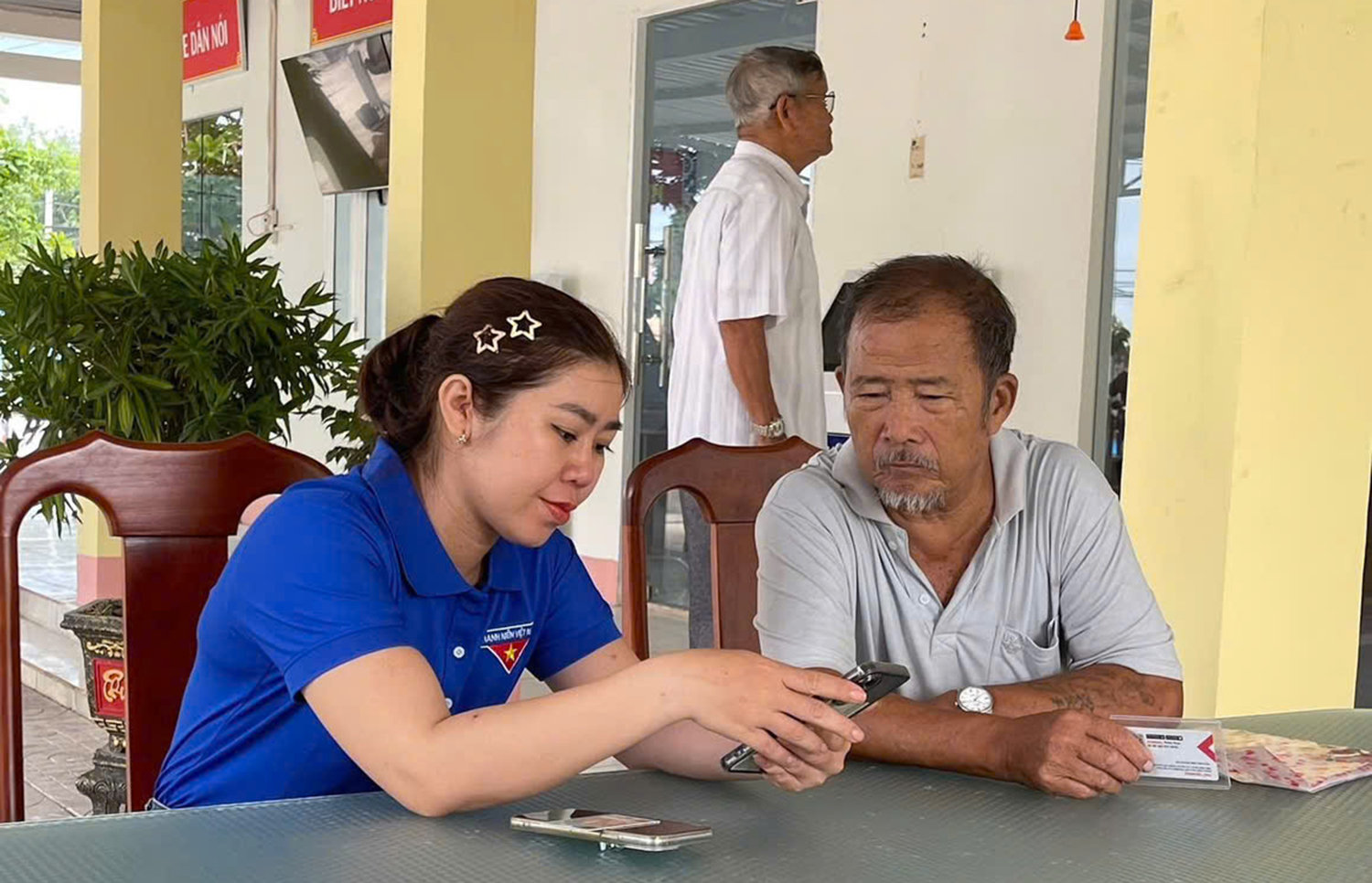 Đoàn viên thanh niên xã Nam Thành hướng dẫn người dân cách sử dụng các ứng dụng tiện ích trên điện thoại.