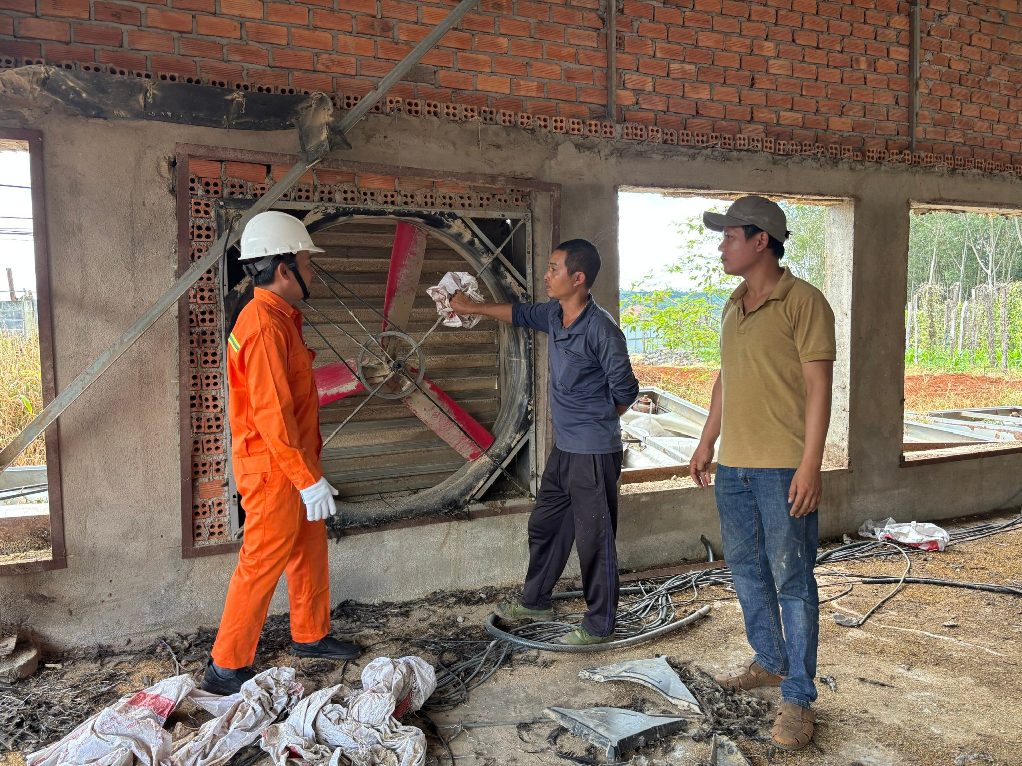 Cán bộ kỹ thuật ngành điện hướng dẫn chủ trang trại gà bảo trì hệ thống quạt thông gió