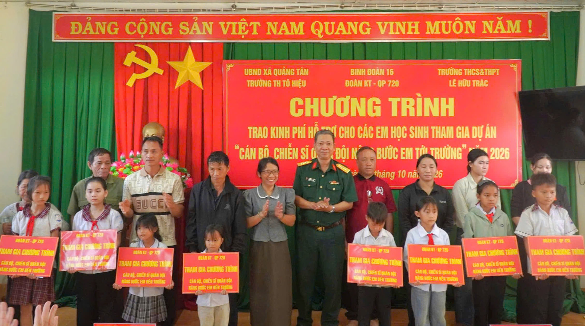 2. Chỉ huy Đoàn KT-QP 720, đại diện nhà trường, cha mẹ và các em học sinh được nhận tiền hỗ trợ chụp hình niệm