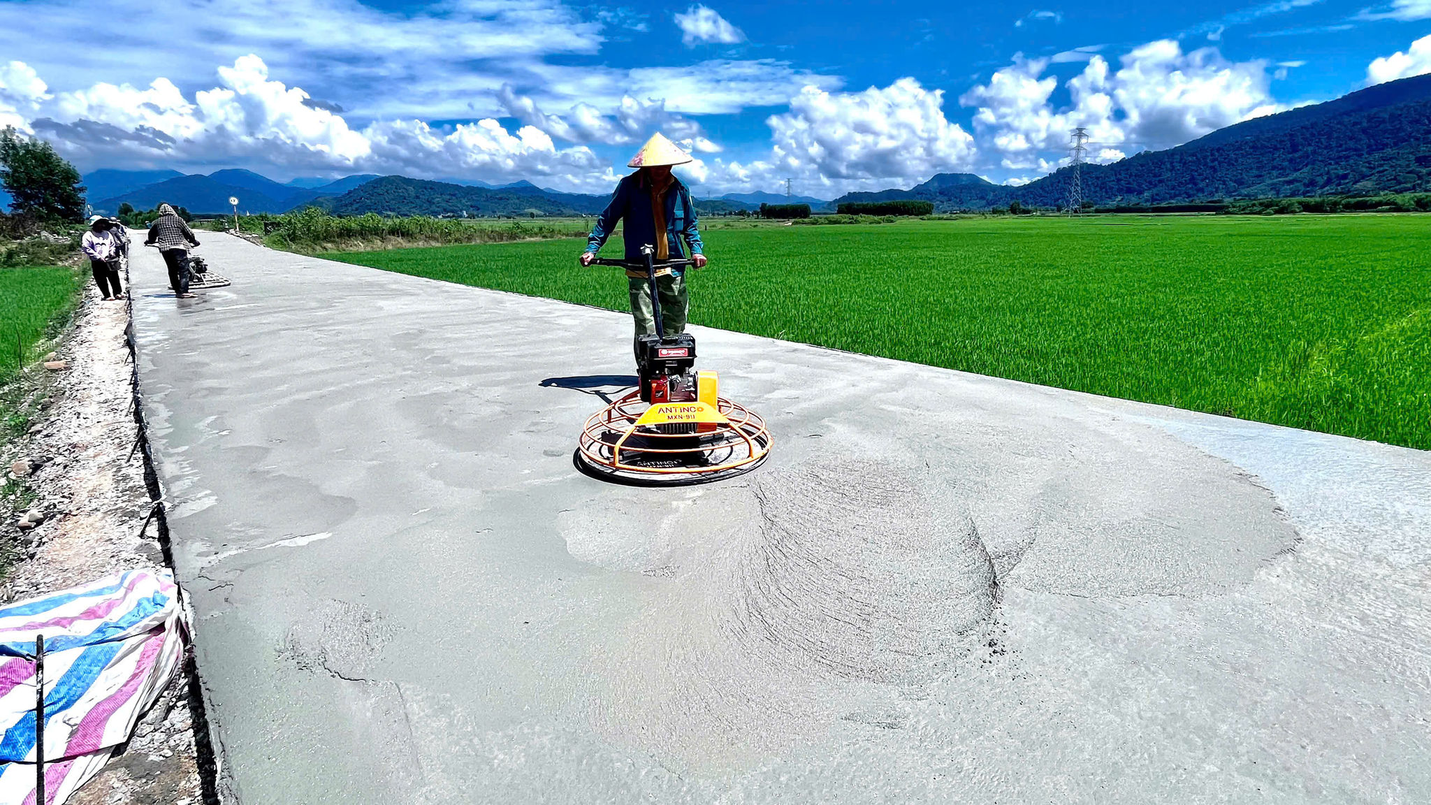 Công nhân đánh mặt bê tông trên công trình đường liên xã Đồng Kho - Tánh Linh (Lâm Đồng)